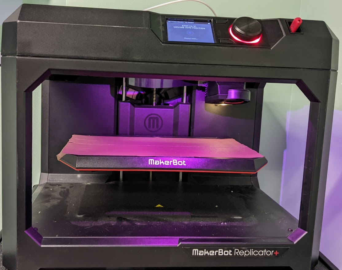 MakerBot Replicator+ printer with raised print bed, demonstrating the automatic Z-offset adjustment process